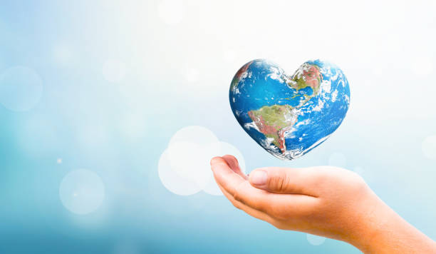 Earth Day concept:  hand hold Earth in Heart shape on Natural background, Elements of this image furnished by NASA stock photo