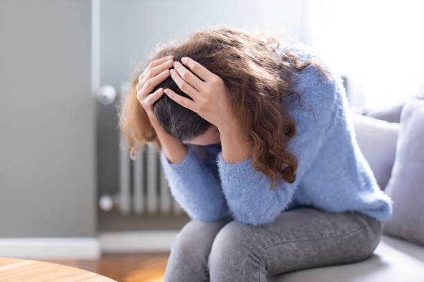 istock Depressed young woman on sofa at home 1218153346