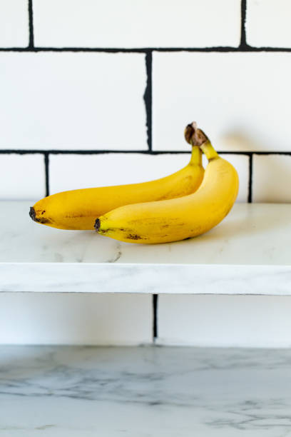 istock Two ripe yellow bananas on white marble background 1218154132