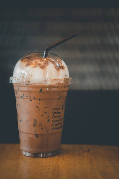 istock Iced coffee mocha in plastic glass on wood table 1218158479