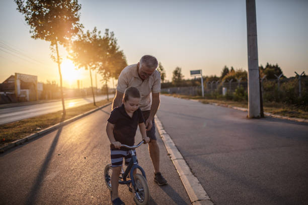 istock Grandfather teaching grandson biking 1218160399