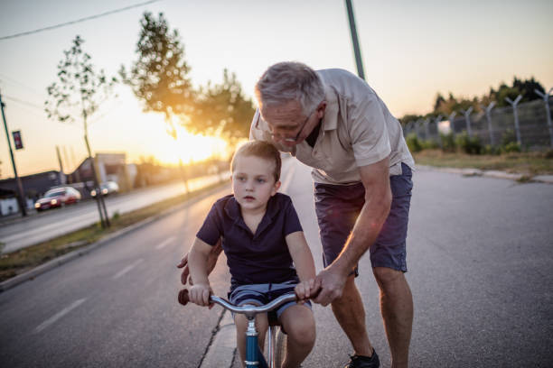 istock Grandfather teaching grandson biking 1218160461