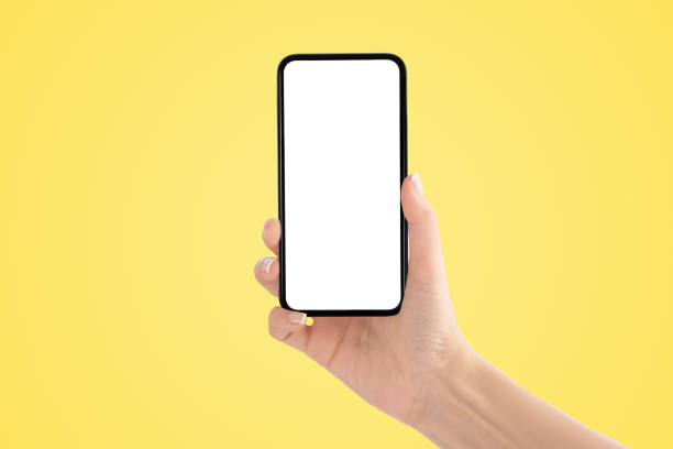 istock Hand holding old black smartphone with Yellow background. 1218160819