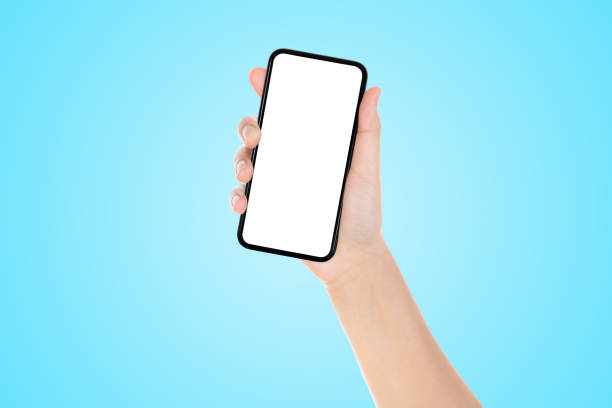 istock Hand holding old black smartphone with blue background. 1218160862