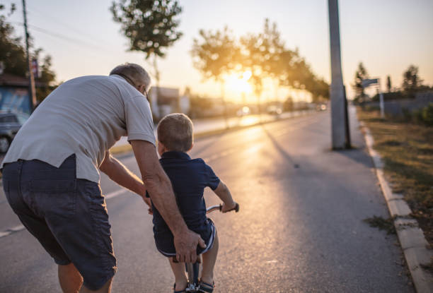 istock Grandfather teaching grandson biking 1218161056
