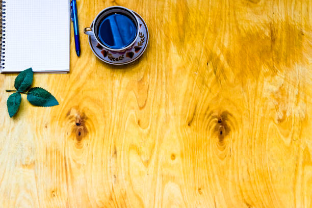 istock Cup of coffe and open notebook on wooden background 1218162025