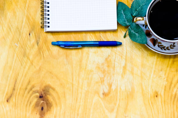 istock Cup of coffe and open notebook on wooden background 1218162091