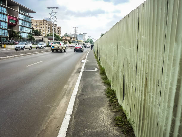 run down sidewalk Partially deteriorated pedestrian crossing sidewalk along a road with cohesive traffic in the African town of Libreville in Gabon gabon stock pictures, royalty-free photos & images