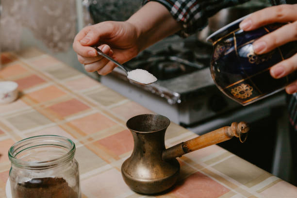 istock Hand pours sugar into cezve for brewing coffee 1218170606