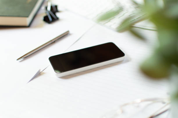 istock Smartphone and pen on top of notepads on a table 1218170921