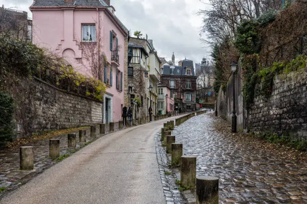 Photo of View on narrow cobbled street among traditional parisian buildings in Paris, France.