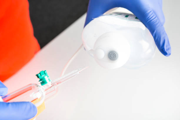 istock First Aid. Preparing an IV drip. Inserting the spike into the port, without touching the end 1218171883