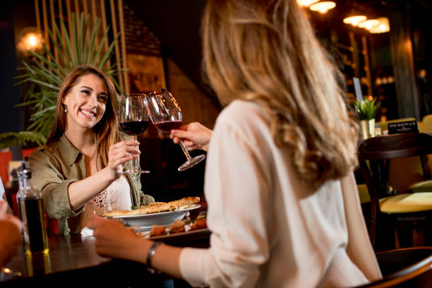가벼운 저녁 식사 동안 레스토랑에서 레드 와인을 마시는 행복한 여성 - bff 뉴스 사진 이미지