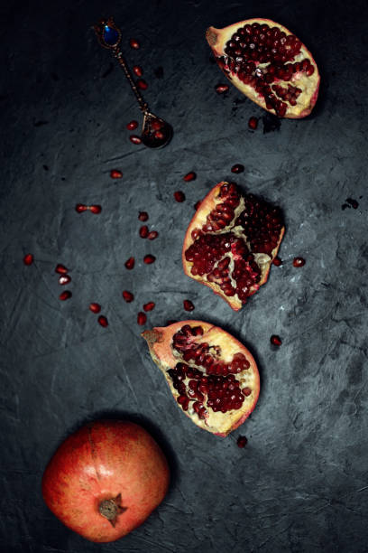istock Ripe pomegranate seeds on a rough black slate background. 1218176324