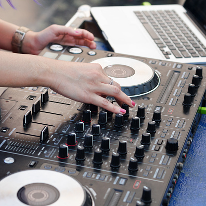 Thai female DJ setting up sound mixer