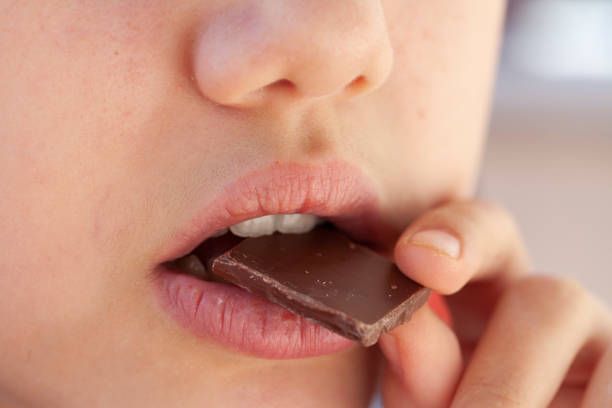 istock girl eating chocolate 1218176578