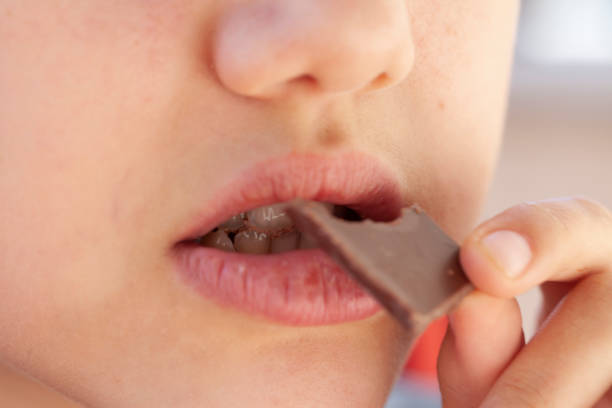 istock girl eating chocolate 1218176579