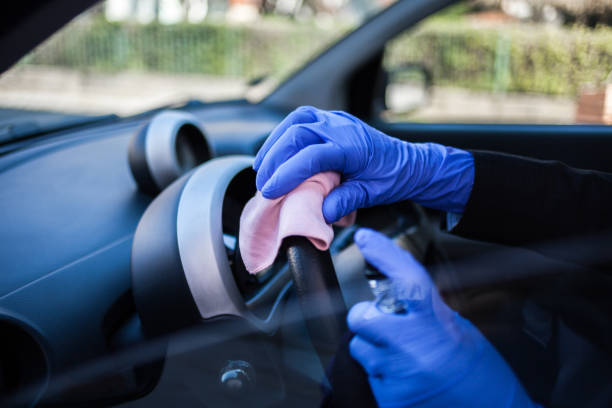 woman wiping down steering wheel - car cleaning inside of indoors imagens e fotografias de stock