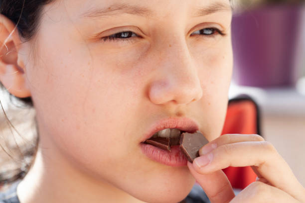 istock girl eating chocolate 1218176639