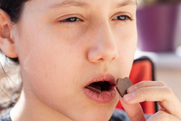 istock girl eating chocolate 1218177196