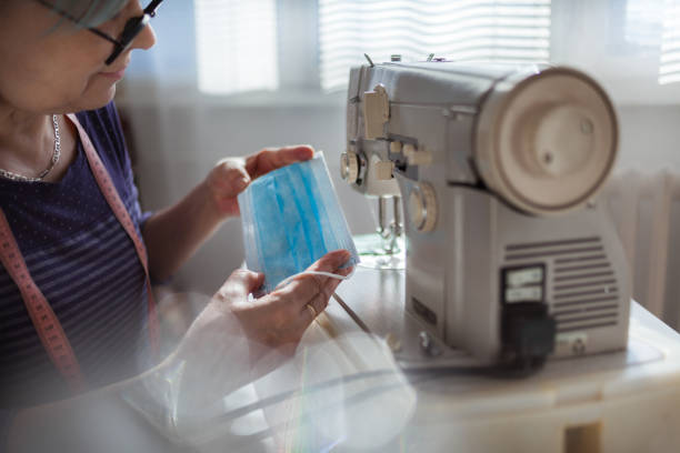 istock Woman working at the sewing machine at home 1218177856