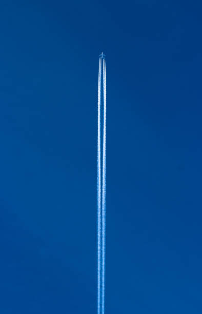 istock Contrail (vapor trail) of an airplane with clear blue sky background 1218185737