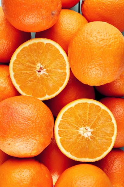 istock Heap of fresh oranges with half slices 1218185998