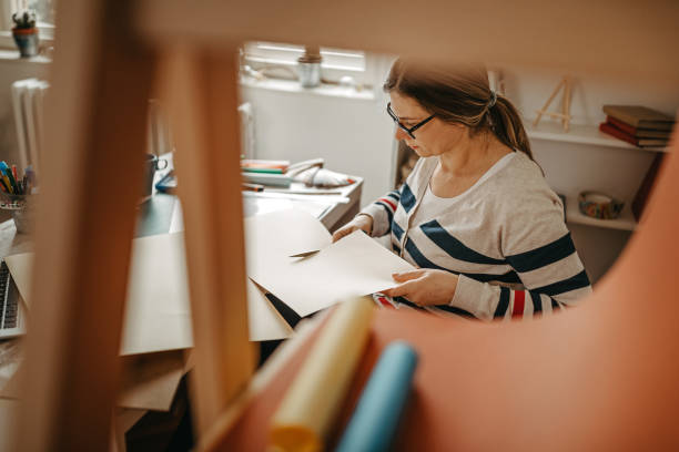 istock Woman cutting paper at work desk 1218187014