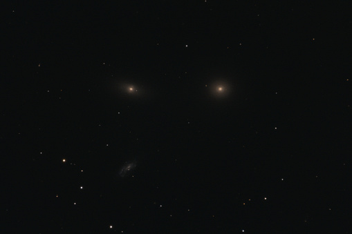 The elliptical galaxy Messier 105, the lenticular galaxy NGC 3384, and the spiral galaxy NGC 3389 in the constellation Leo photographed with a Maksutov telescope from Mannheim in Germany.