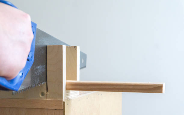 istock Man cutting a wooden slat with a saw 1218189765