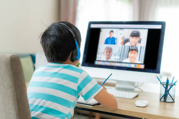 istock Asian boy student video conference e-learning with teacher and classmates on computer in living room at home. Homeschooling and distance learning ,online ,education and internet. 1218190240