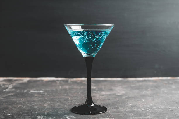 istock Blue martini cocktail with cherry on the rustic background 1218191858