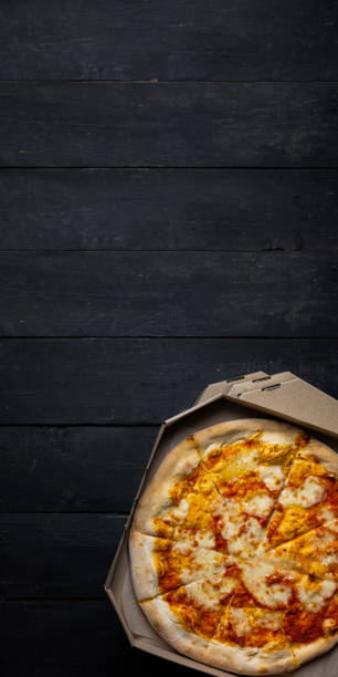 istock Pizza margherita in an open delivery box, dark backdrop with text space. 1218192345