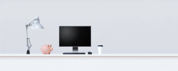 istock Clean white table with piggy bank and desktop computer. 1218193056