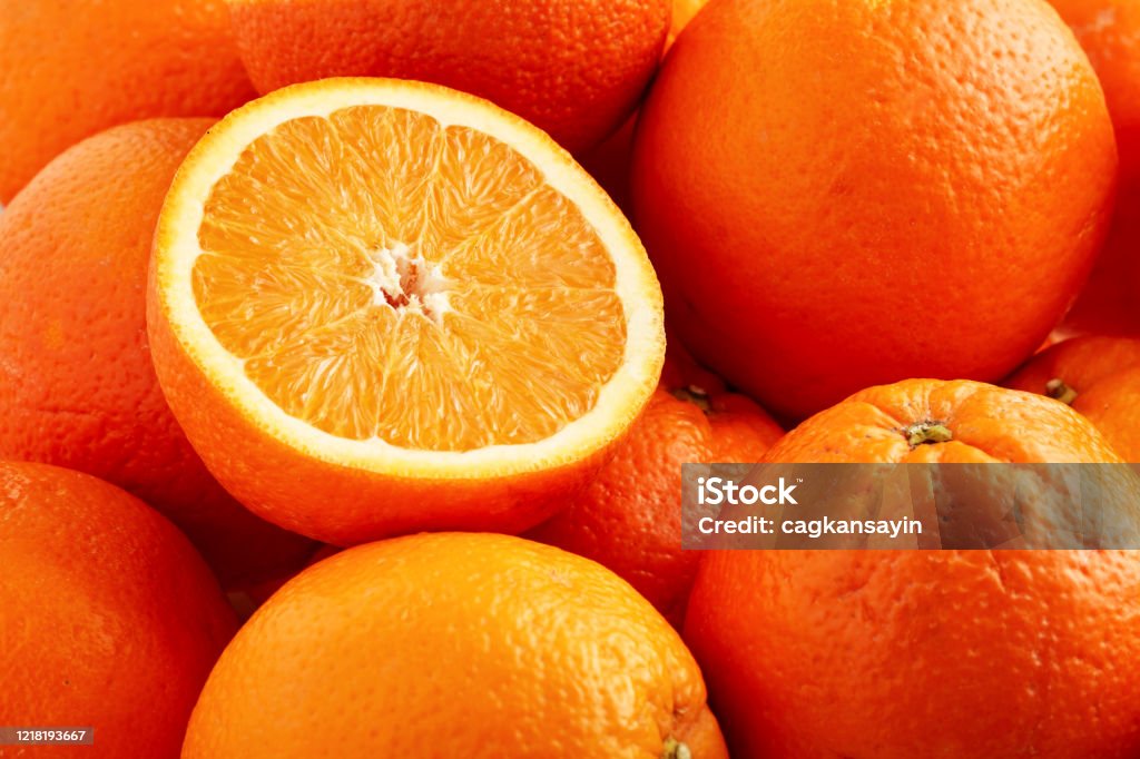 Heap of fresh oranges with one half slice Heap of fresh oranges with one half slice. Close up view. Orange - Fruit Stock Photo