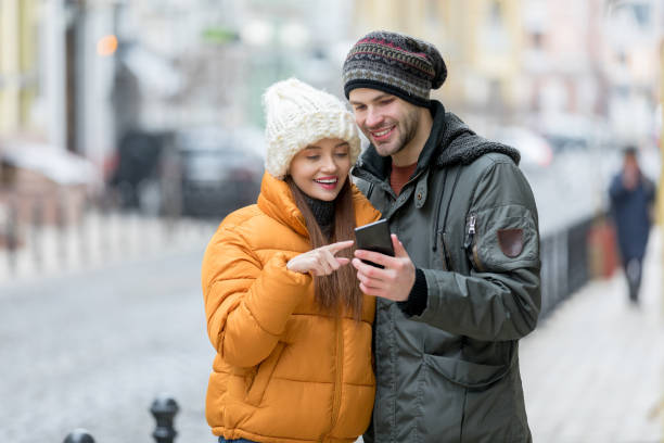 istock Young couple using mobile phone outdoors 1218194742