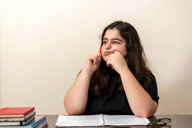 istock 13 years old girl doing homework 1218194820