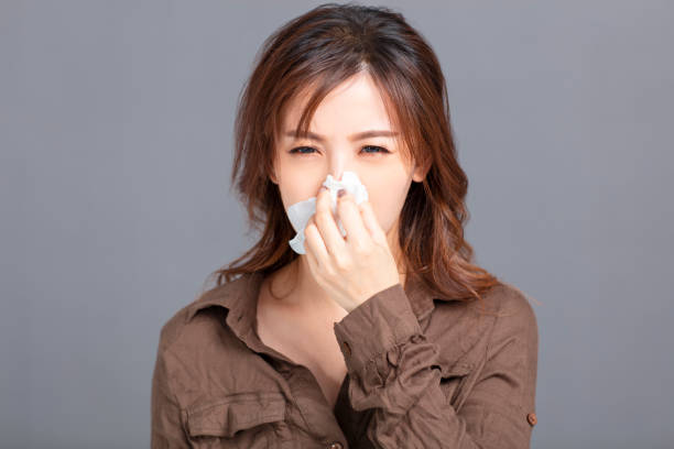 istock Sick young woman  blowing her nose 1218196221