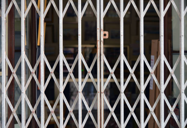 Metal Grid closing the store entrance. Shop closure under COVID-19 global pandemic.