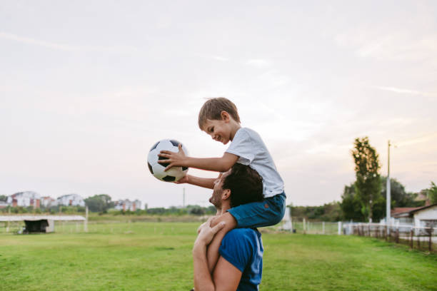 Smiling soccer players Photo of father and son on a soccer court sports ball photos stock pictures, royalty-free photos & images