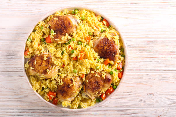 istock Chicken thighs with rice, carrot and peas 1218204524