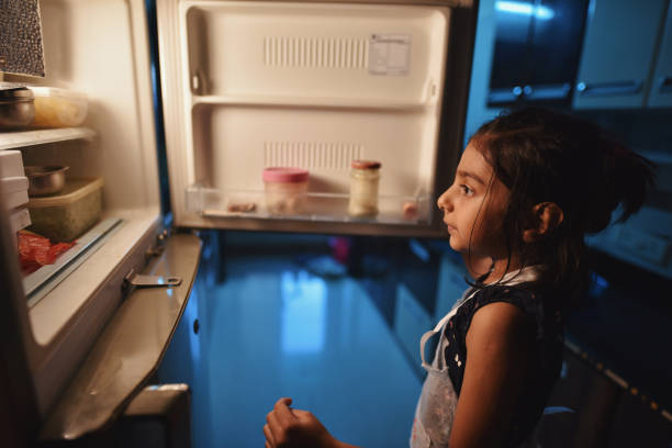istock Girl looking for some snacks in the refrigerator 1218204578
