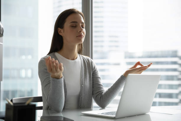 istock Young woman employee meditating practicing yoga at workplace 1218204697