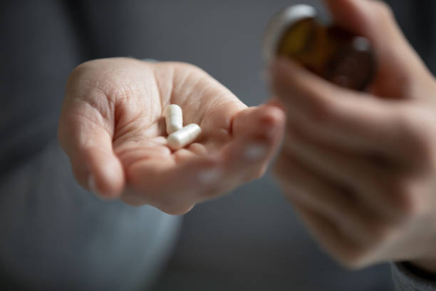 処方された抗生物質の丸薬やビタミンを服用している若い女性 - prozac ストックフォトと画像