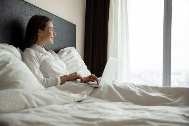 istock Happy girl relax in bed at home using laptop 1218204750