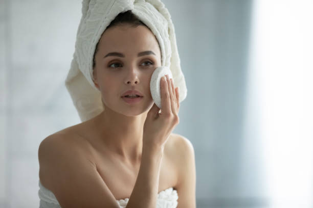ミレニアル世代の女性は、ホームバスルームで顔の剥離を行います - human face rubbing women beauty treatment ストックフォトと画像