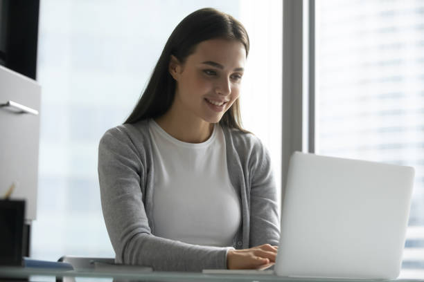 istock Happy young woman work on laptop typing 1218204772