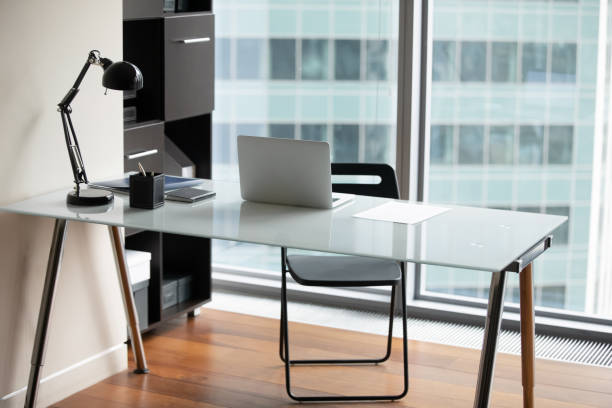 Office desk with modern laptop and paperwork on it Empty office desk with modern laptop, paperwork contract or letter correspondence on top, glass table comfortable furniture of businessperson or employee in boardroom, interior design concept chairperson stock pictures, royalty-free photos & images