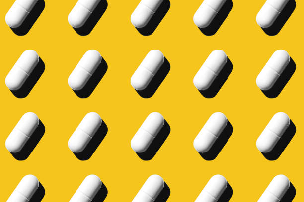 istock Trendy pattern made with Pharmaceutical medicine white pills on yellow background. 1218205164