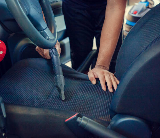 istock Worker on a car wash cleaning car interior with vacuum cleaner 1218205307